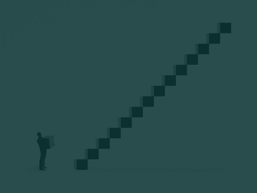 A man holds a box while looking up at a steep staircase.