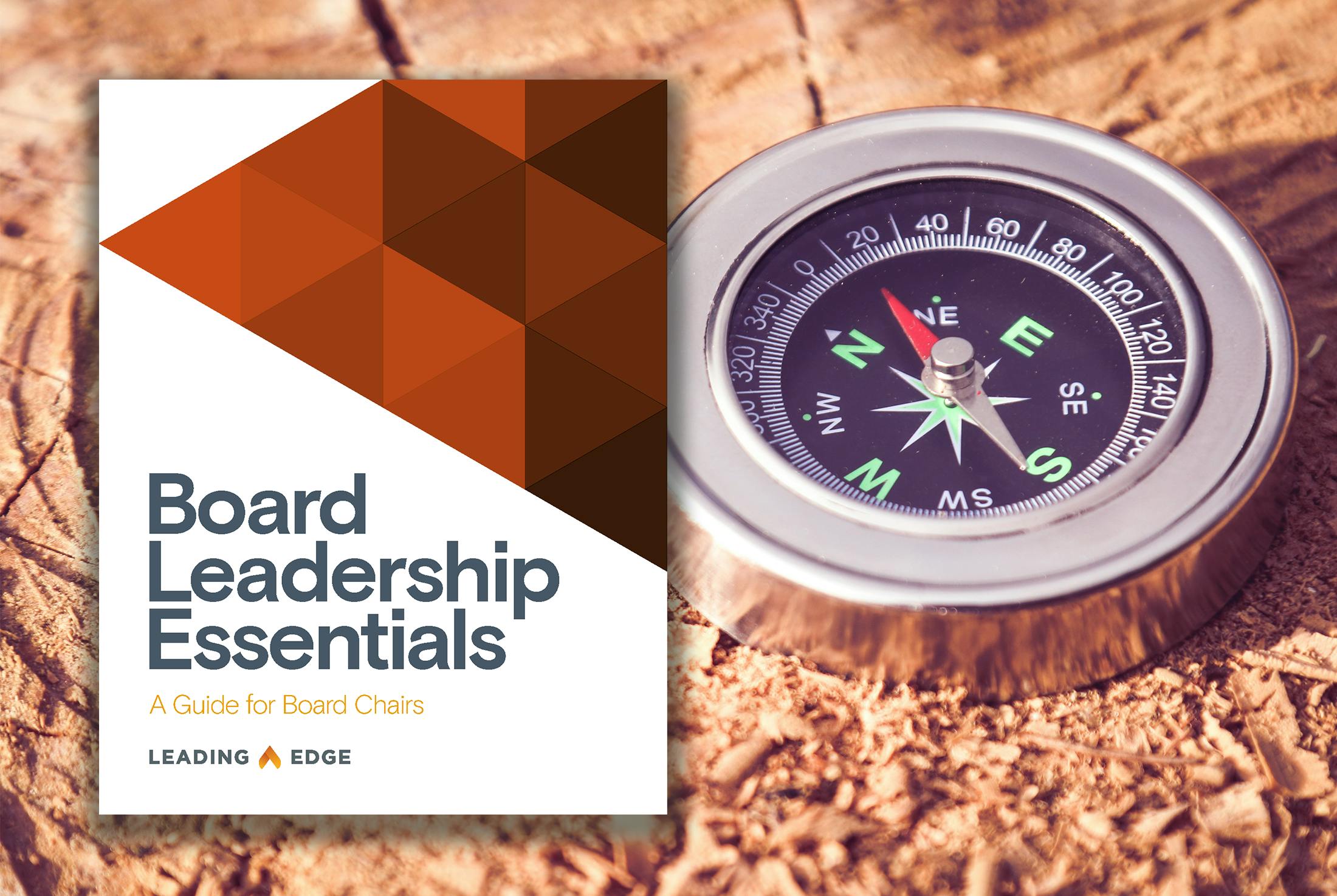 The "Board Leadership Essentials: A Guide for Board Chairs" cover by Leading Edge, alongside a silver compass on a wooden surface