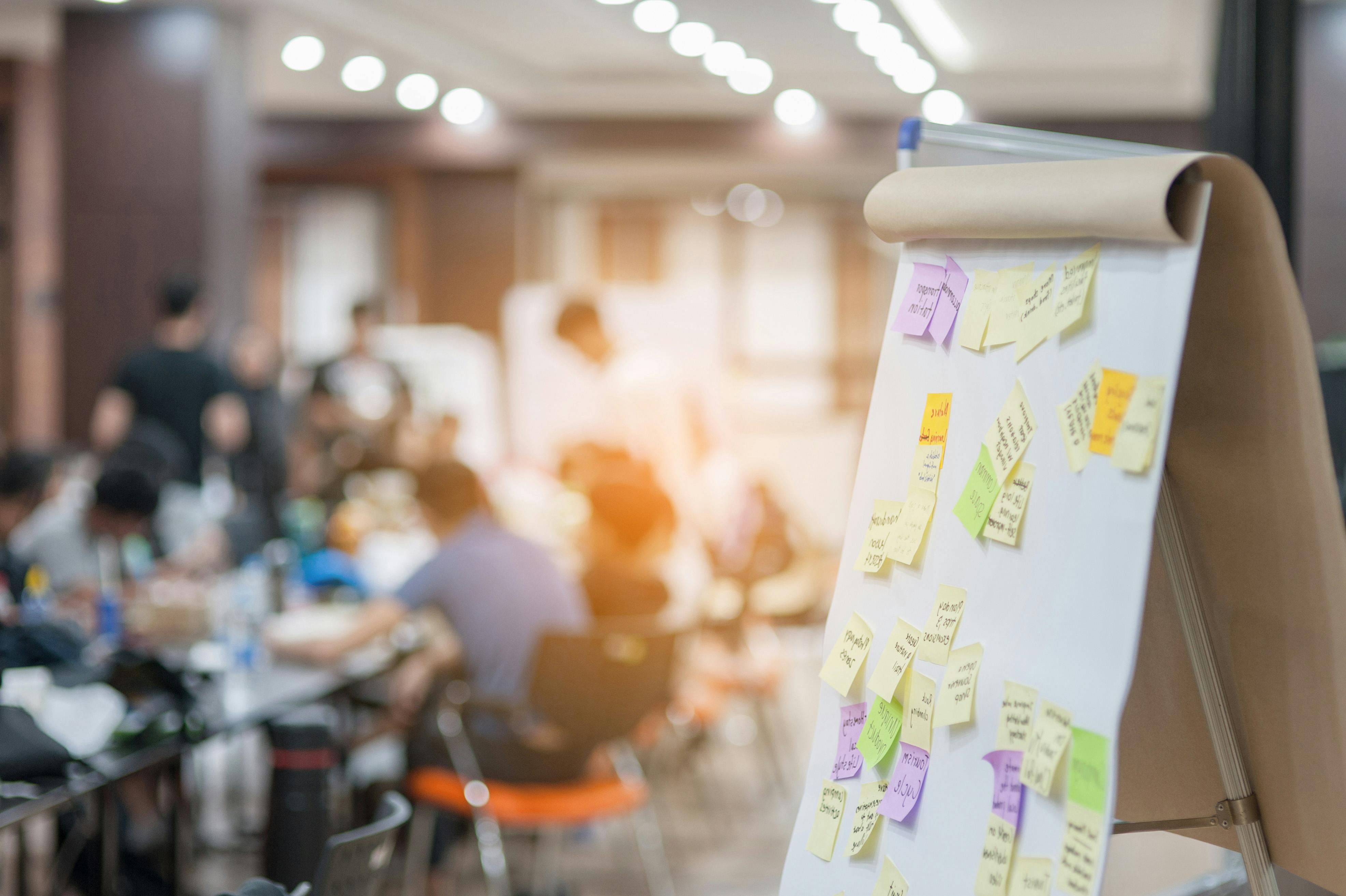 Sticky notes are seen on an easel pad during a workshop.