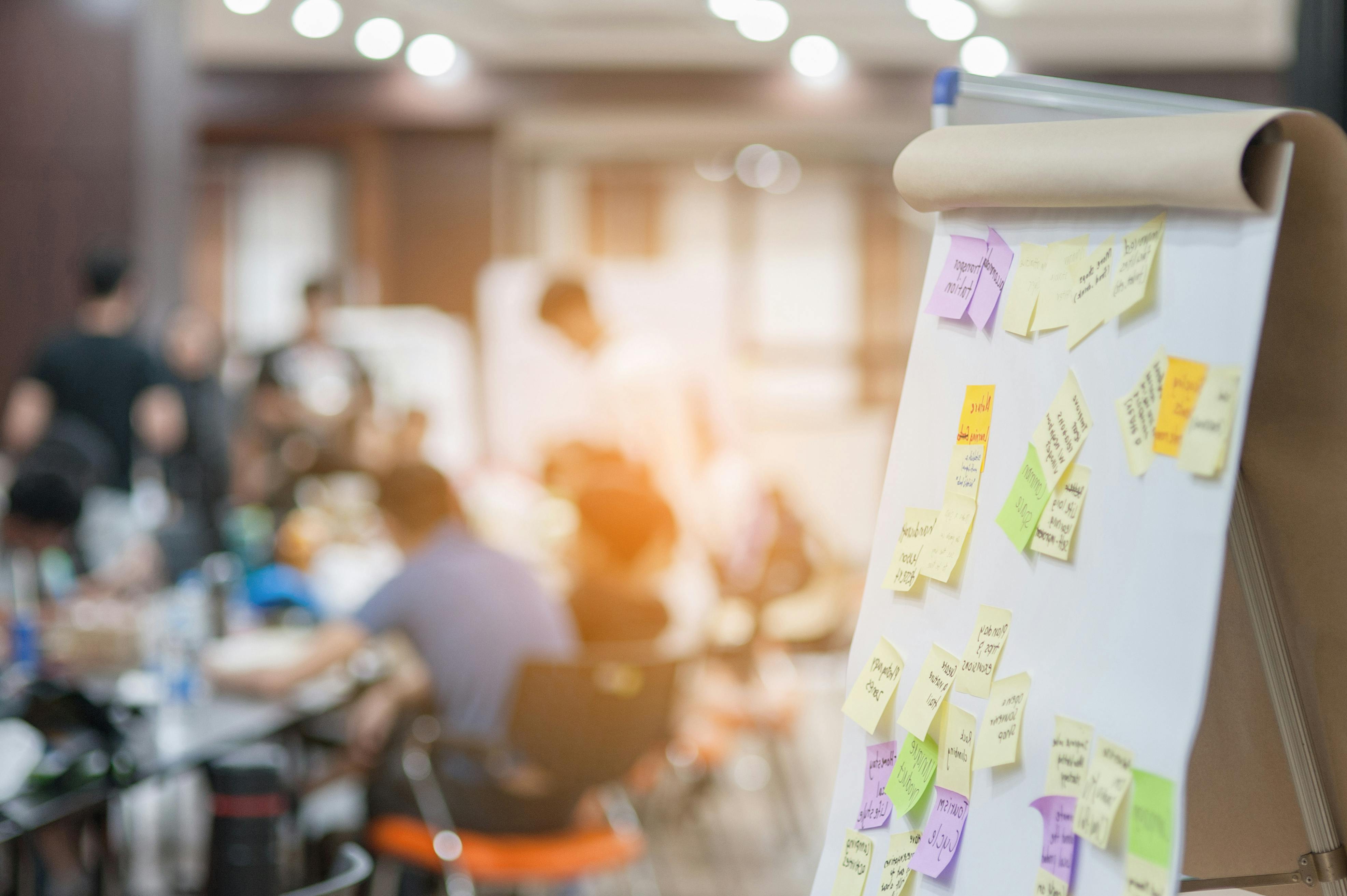 Sticky notes are seen on an easel pad during a workshop