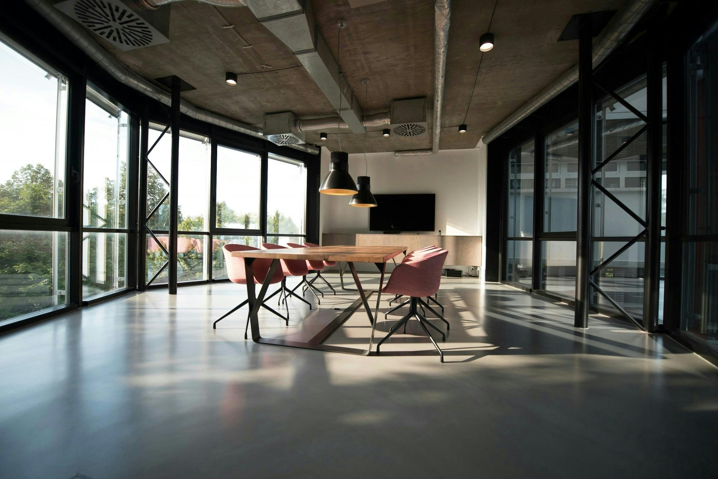 Empty conference room with windows surrounding a conference table and chairs