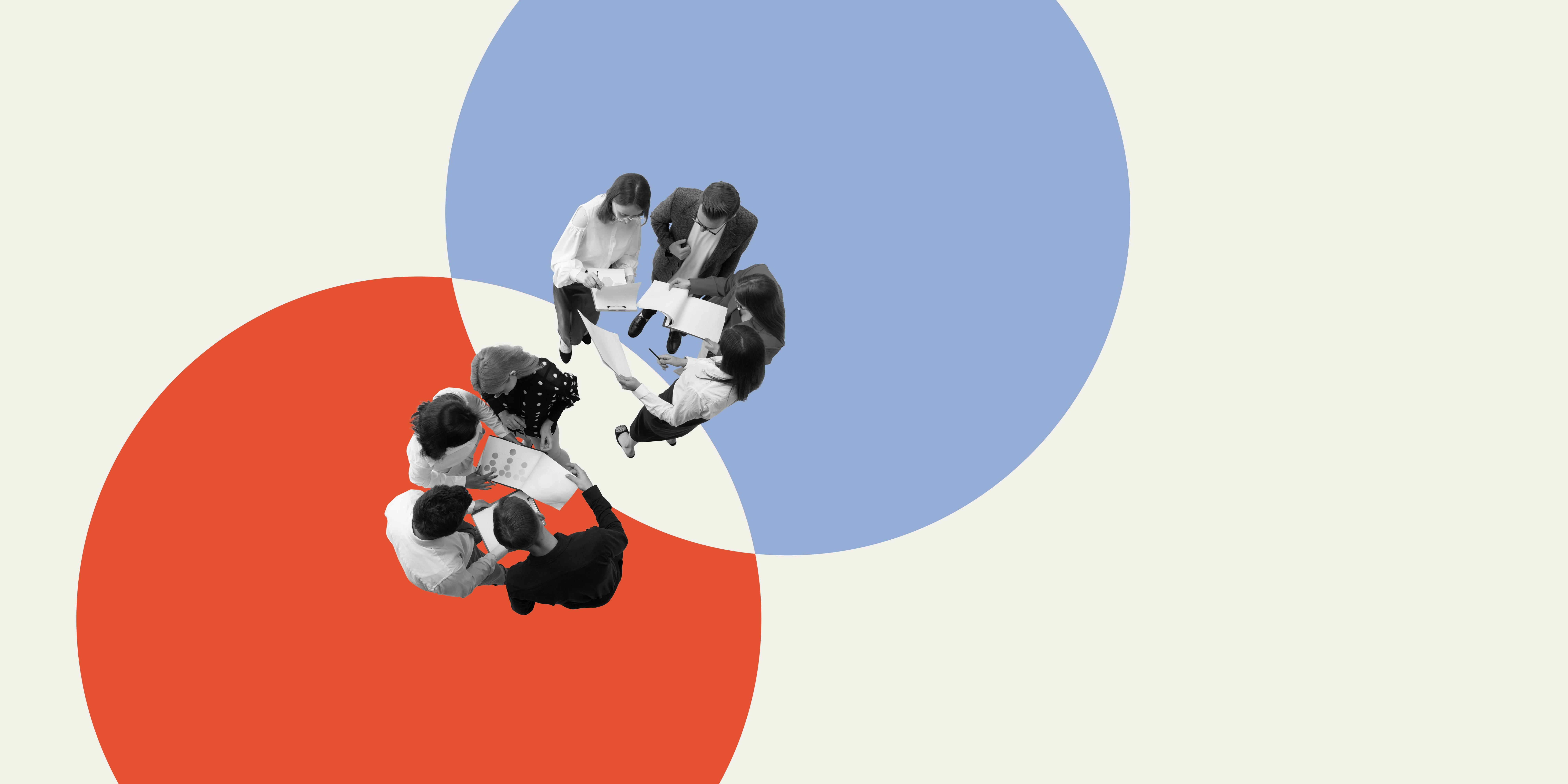 Overhead view of two groups collaborating within overlapping red and blue circles, symbolizing teamwork and shared goals.