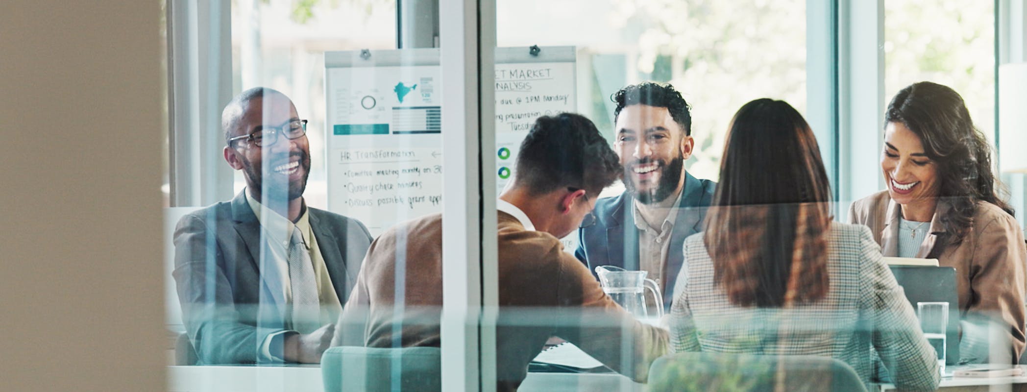 Employees laugh during a meeting.