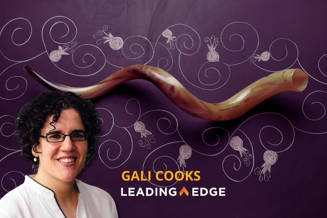 Blackboard background decorated with chalk-style swirls and pomegranates. At the center is a large shofar (ram’s horn). In the lower left is a photo of Gali Cooks with the text “Gali Cooks” in orange above “Leading Edge” in white.