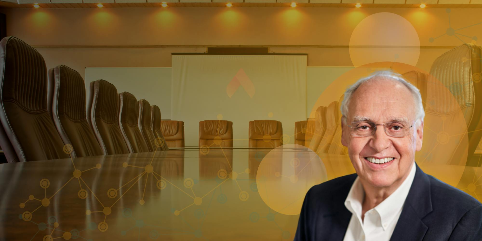 (R-L) Image of Joe Kanfer, Board Chair, Leading Edge, against background of brightly lit boardroom.