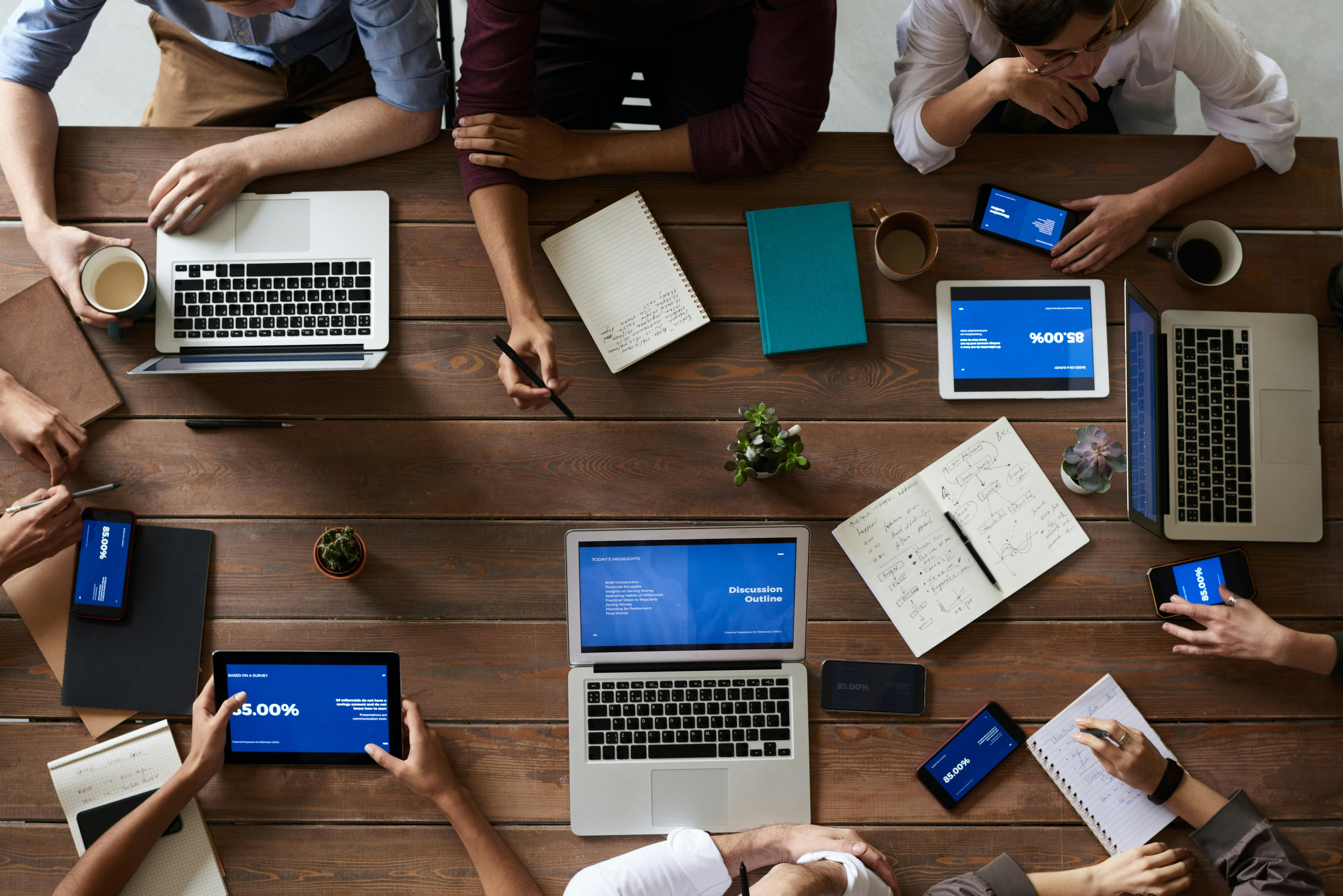 Top view photo of people sitting at wooden table