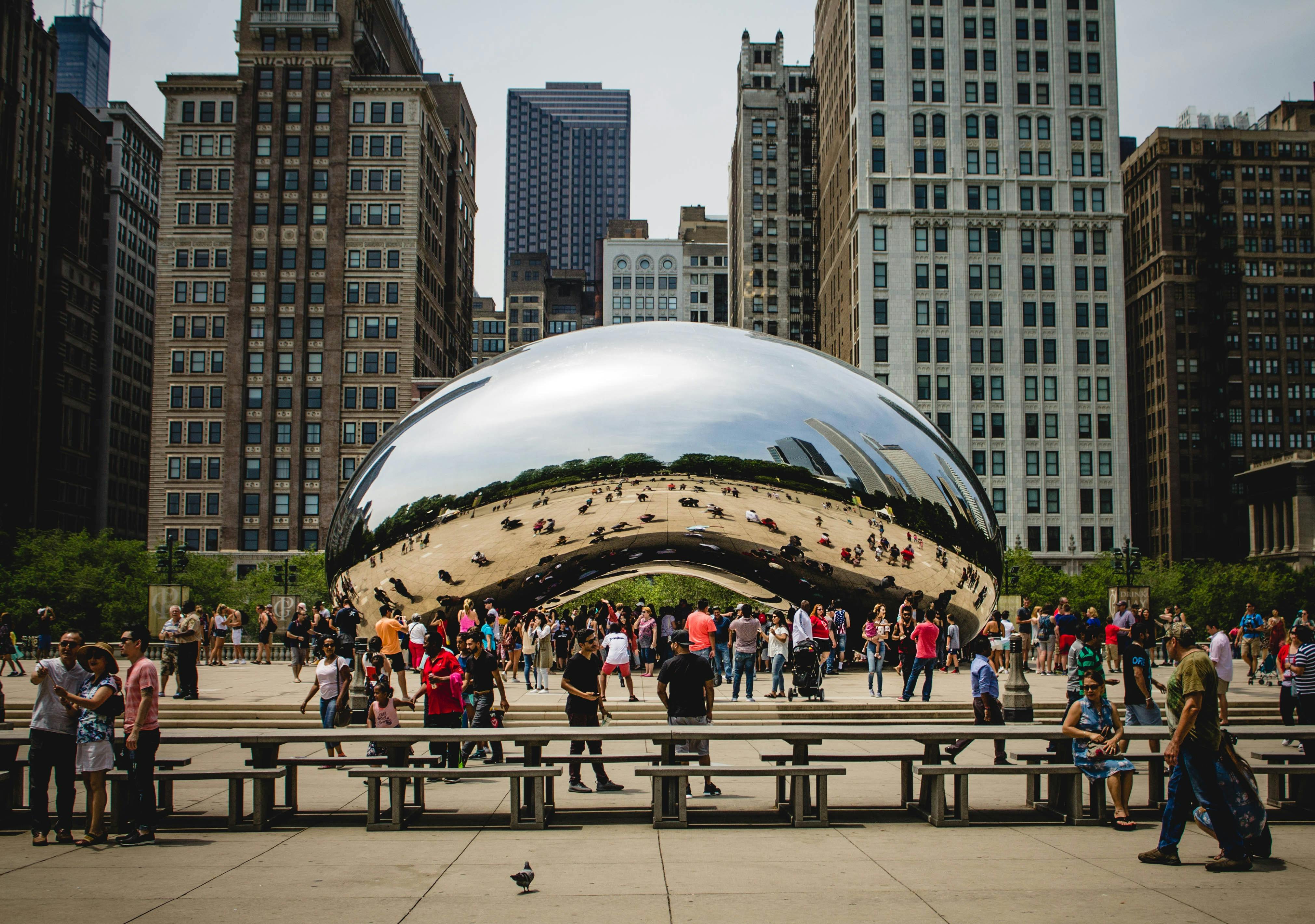 A crowd mills around the sculpture, "Cloud Gate," in Millennium Park, Chicago, IL.