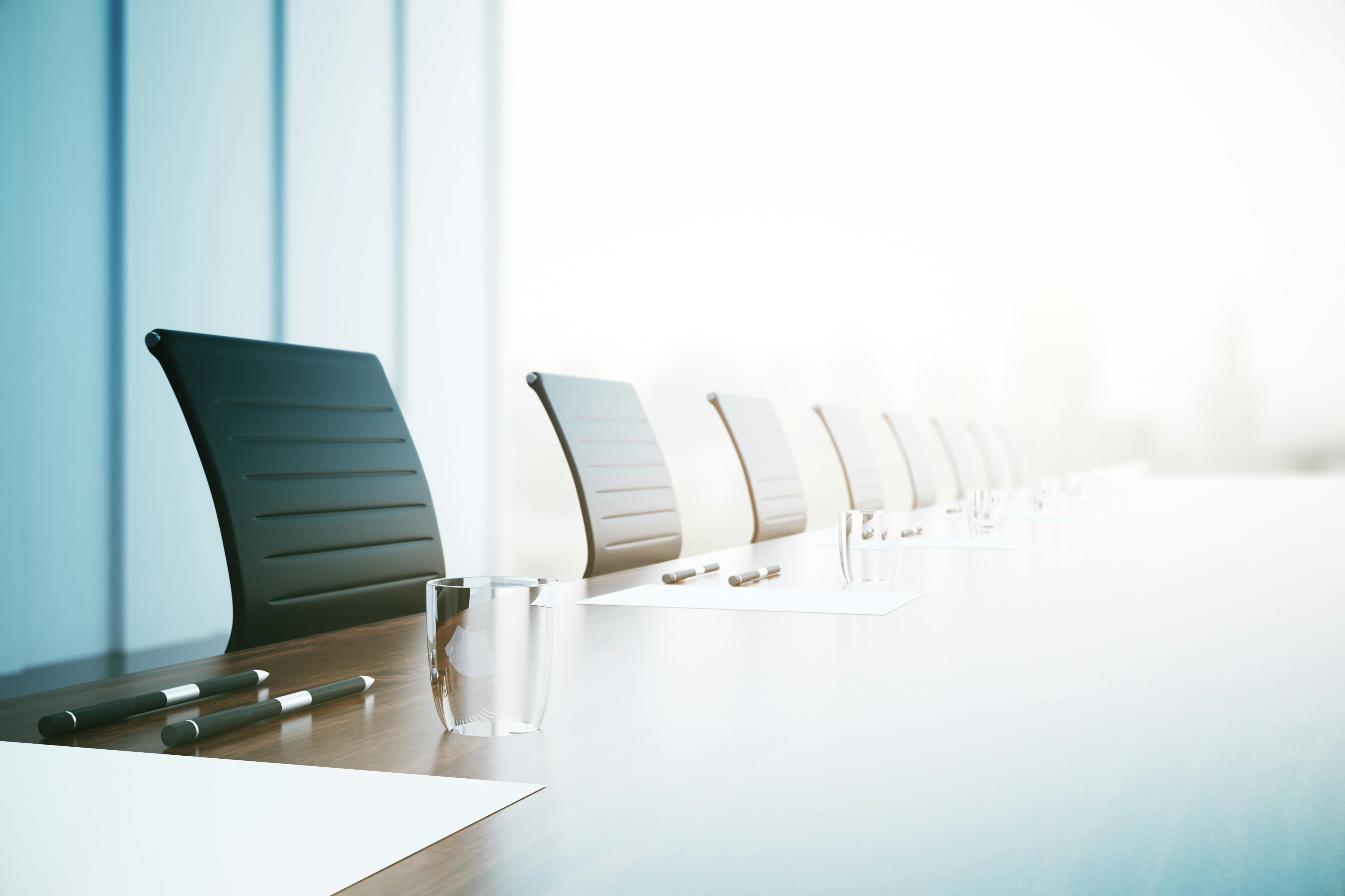 Close up of a large conference table with chairs in a meeting room