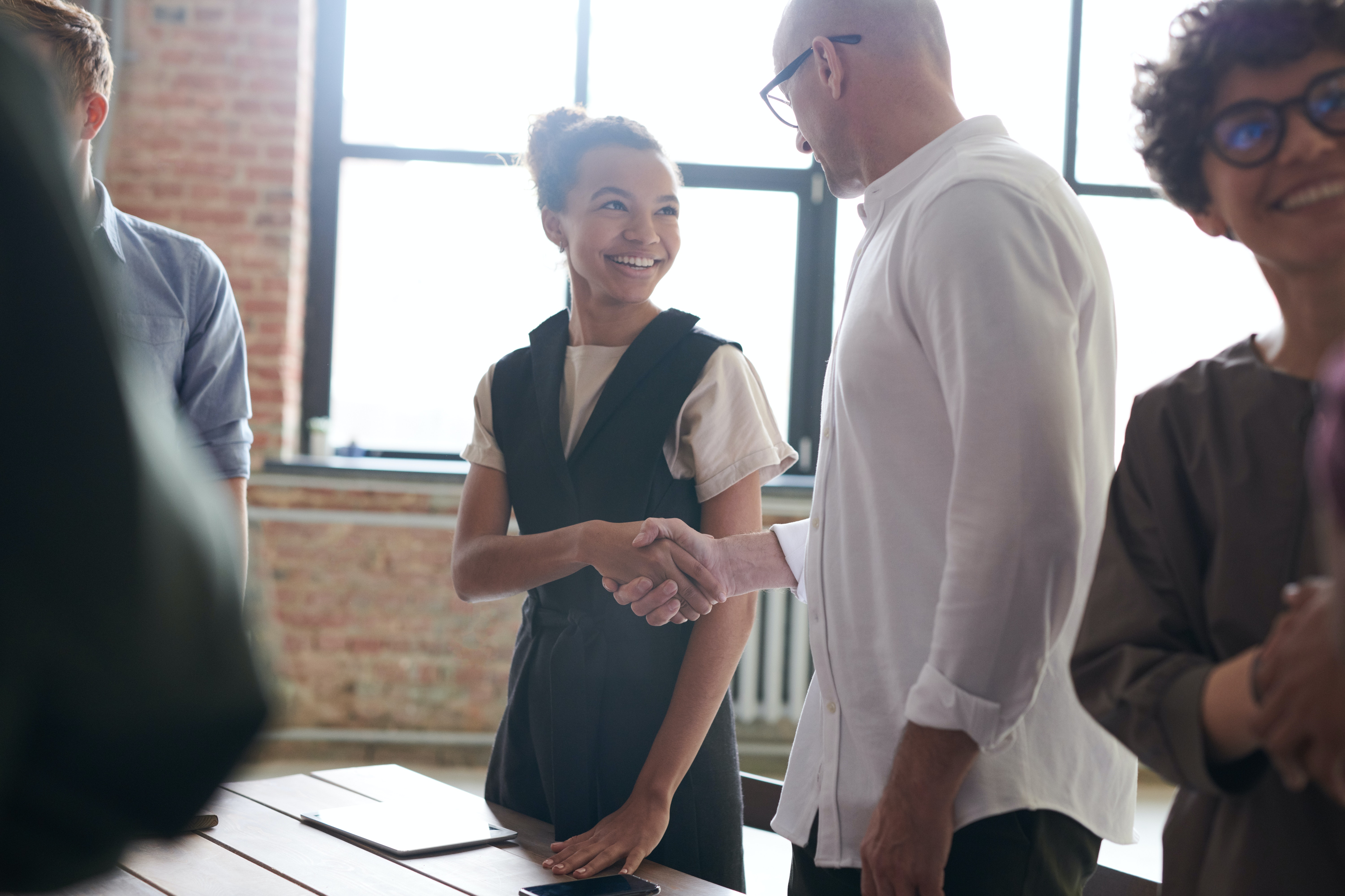A man and woman smiling and shaking hands