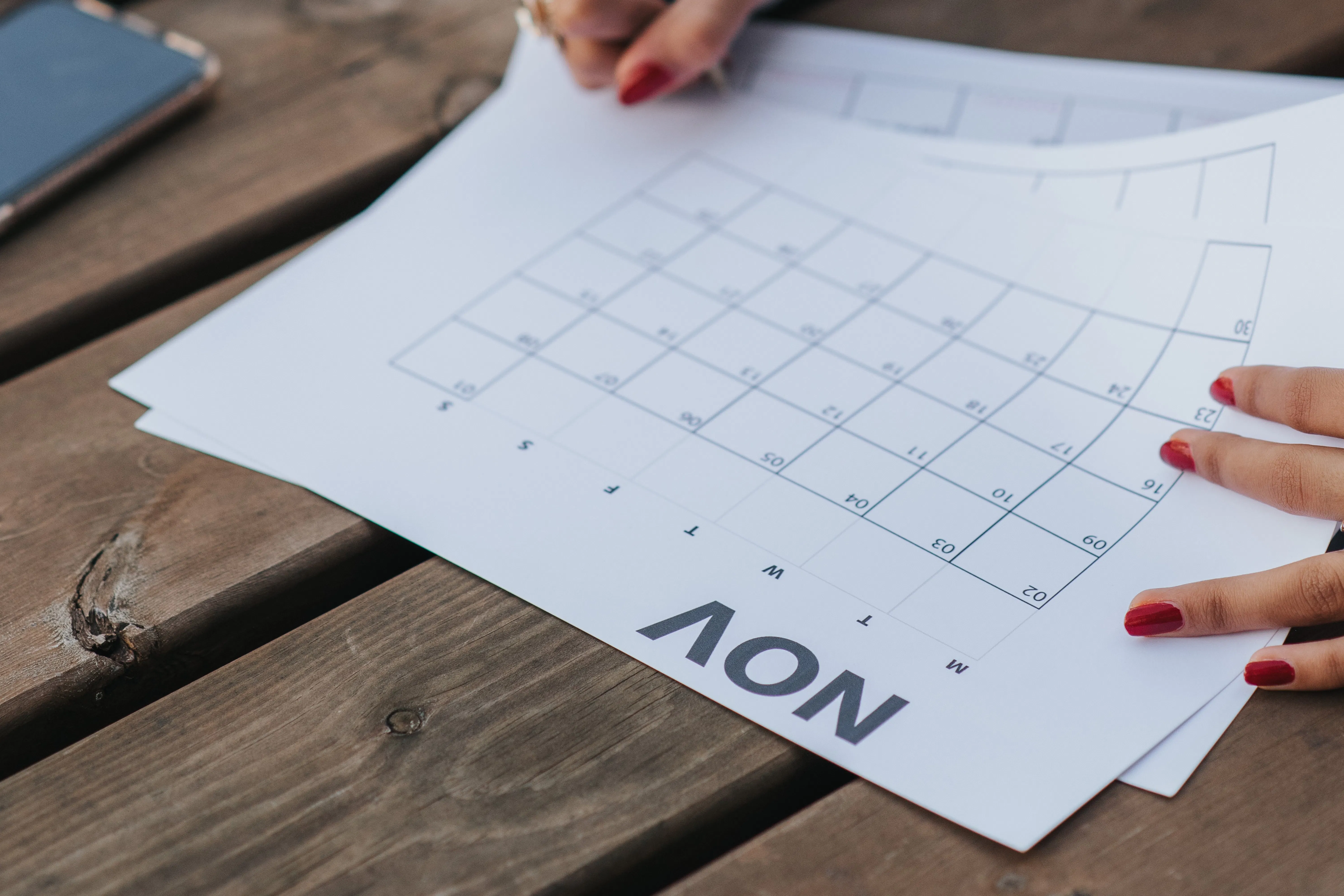 Hands writing on a calendar page