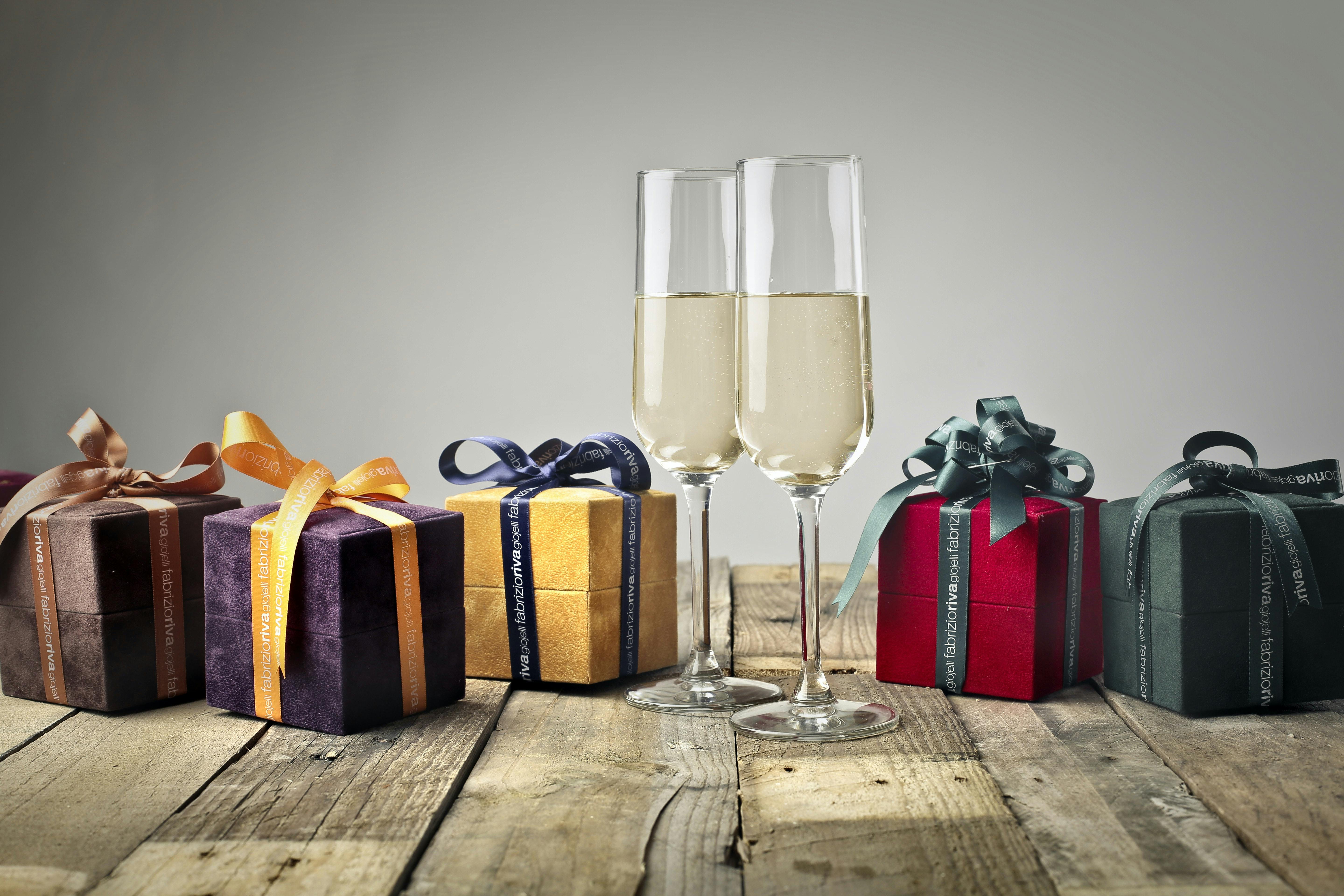 Small gifts boxes with ribbons and two flutes of champagne
