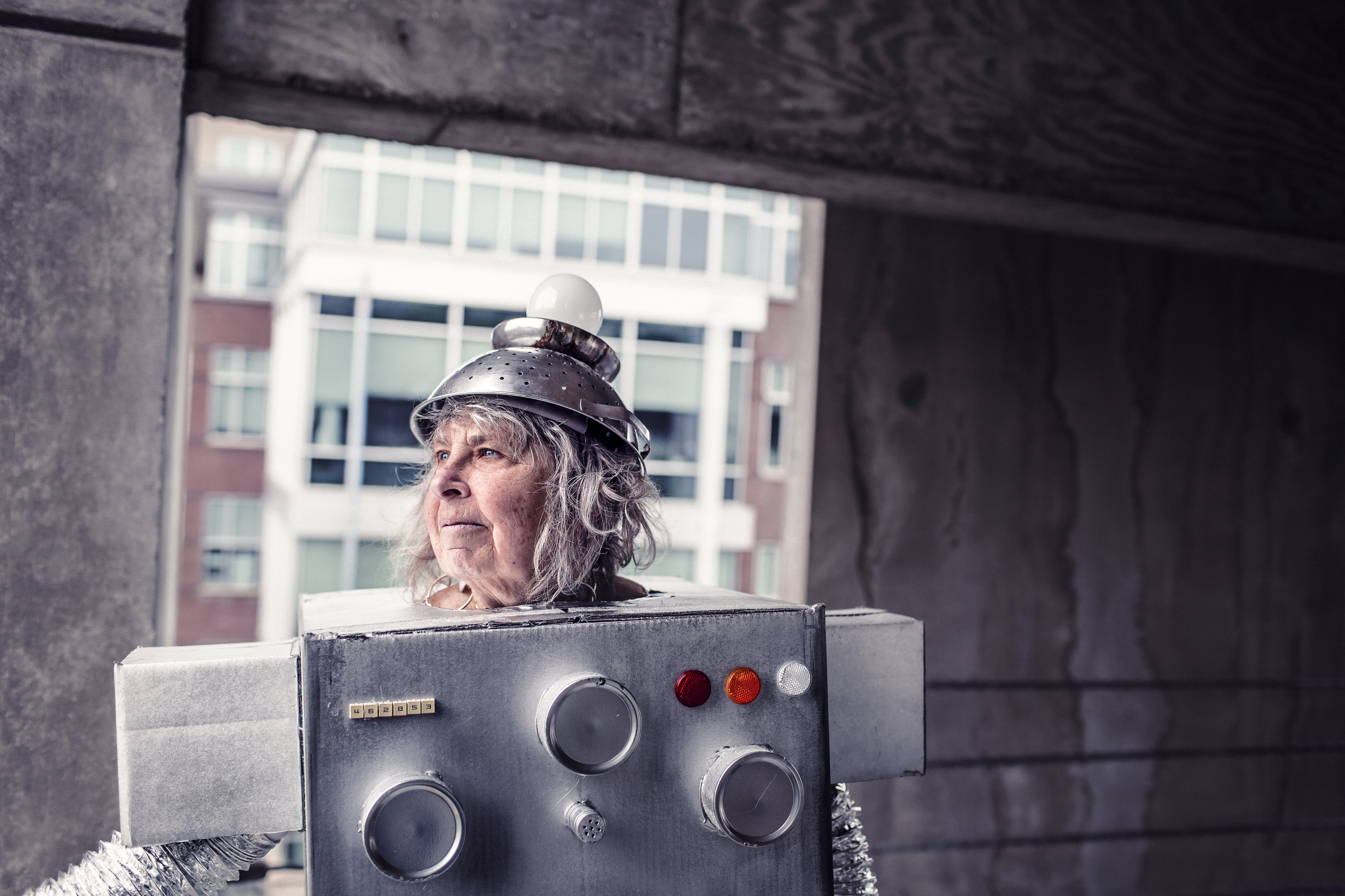Older woman wearing a cardboard robot costume and an upside-down colander on her head for a hat