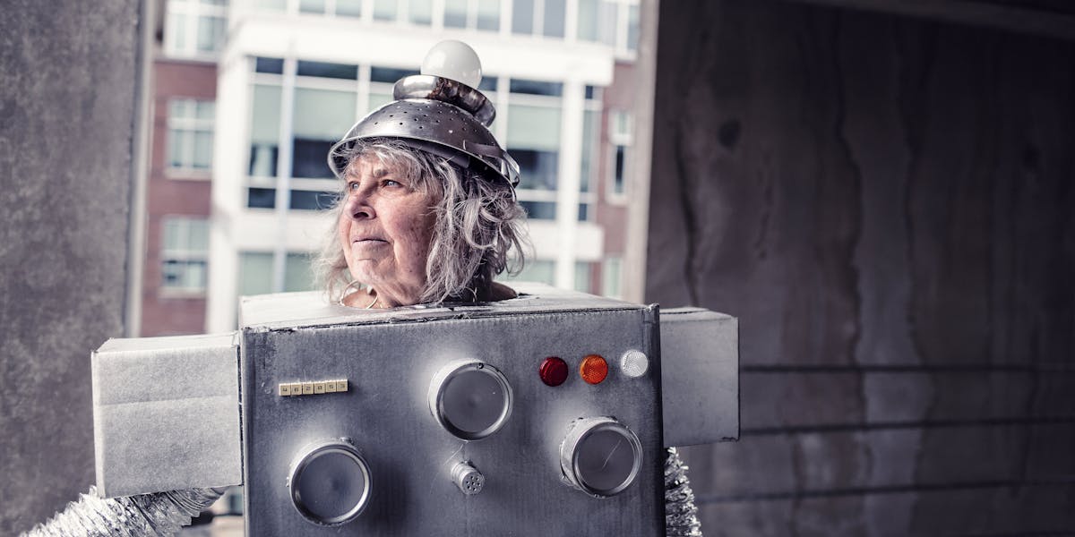 Older woman wearing a cardboard robot costume and an upside-down colander on her head for a hat
