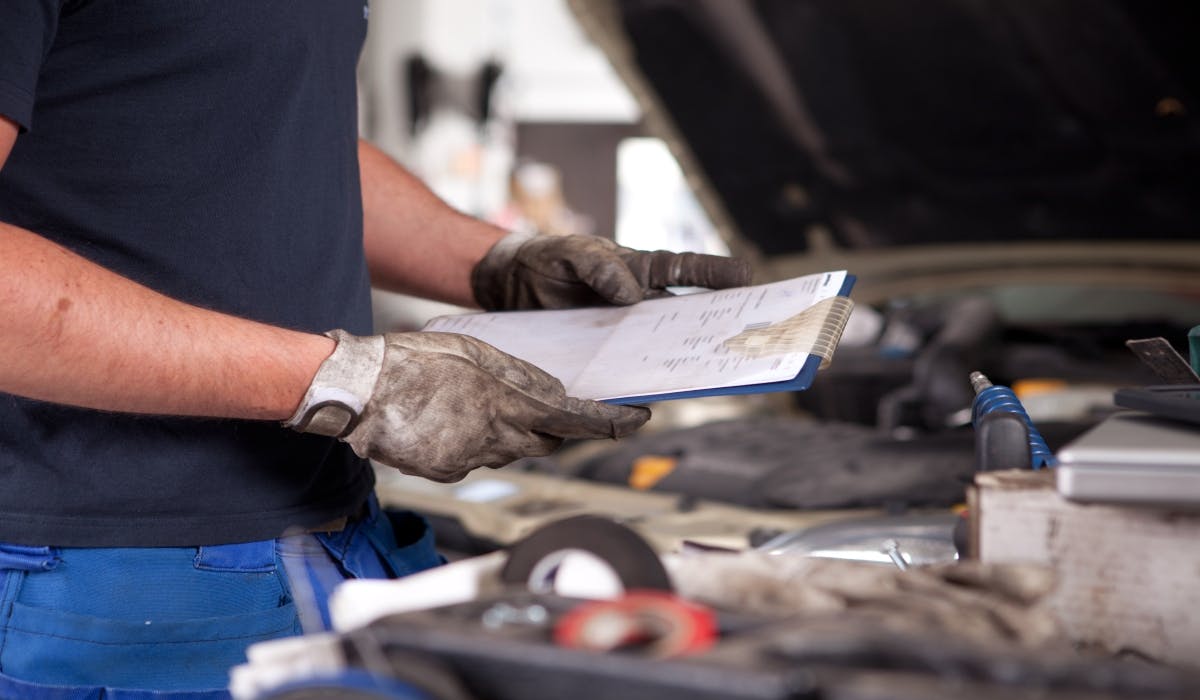 mechanic looking over clipboard