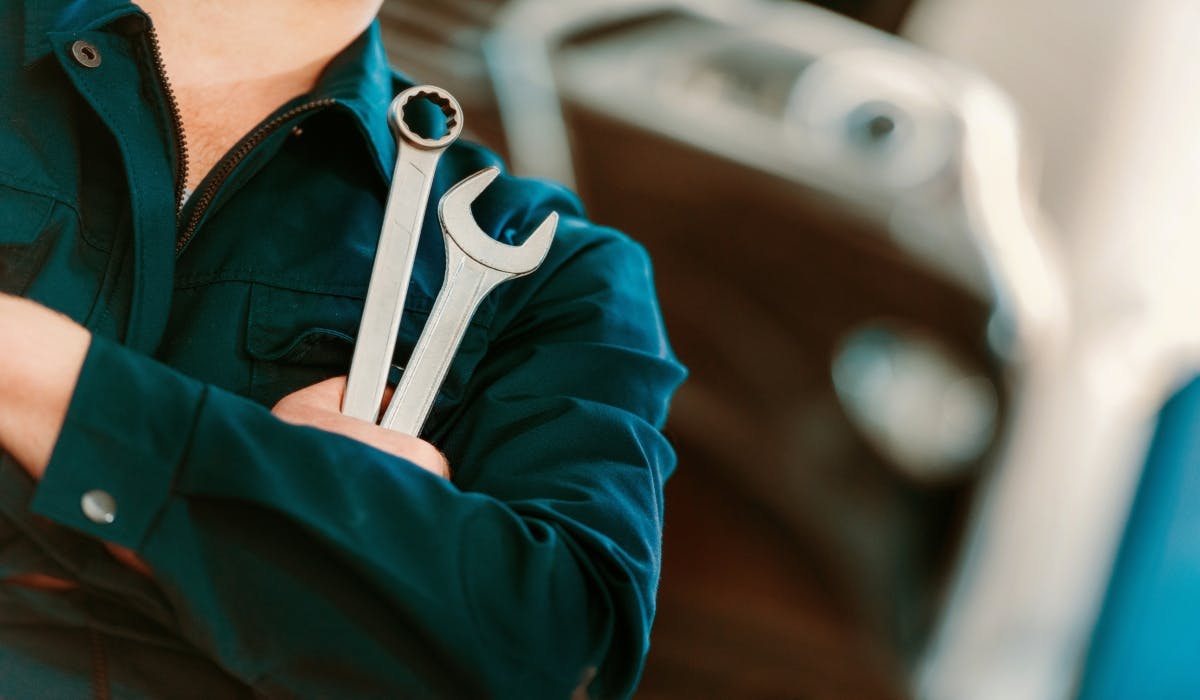 car mechanic holding wrenches