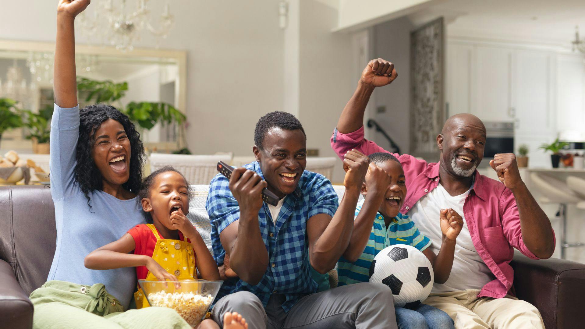 photo d’une famille africaine qui regarde un match de foot