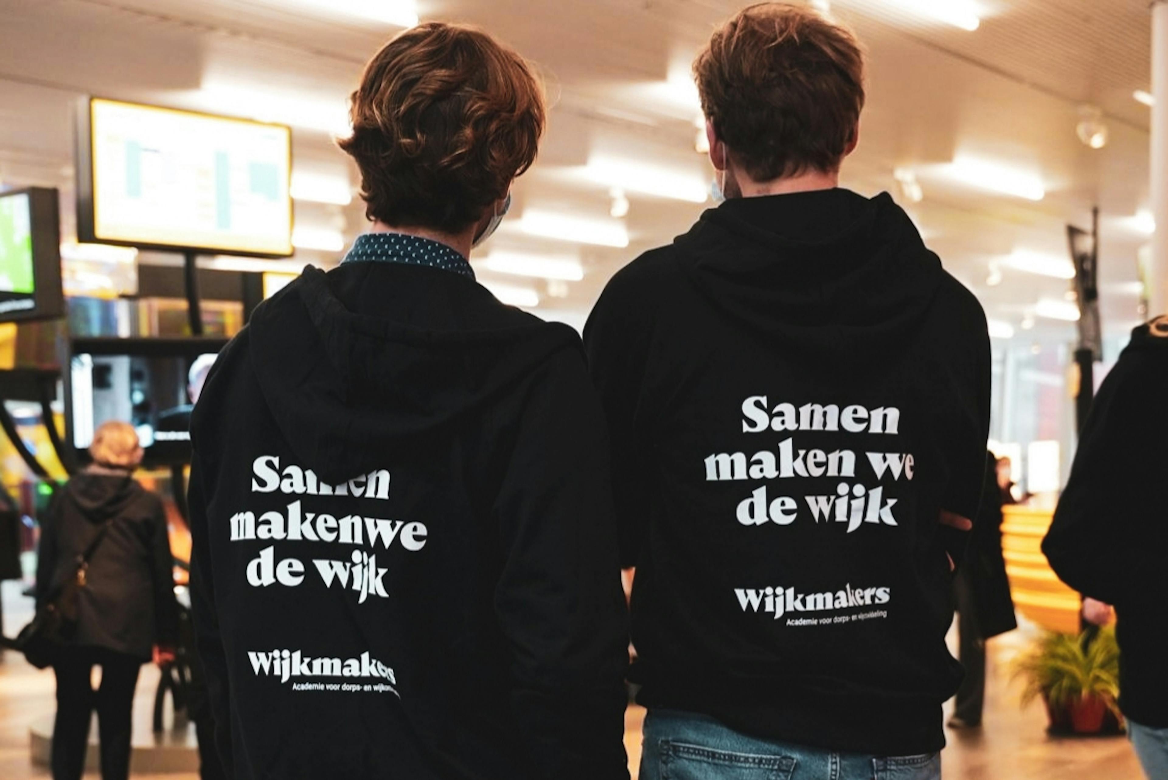 Twee personen met een trui aan van Wijkmakers met de opdruk 'Samen maken we de wijk'