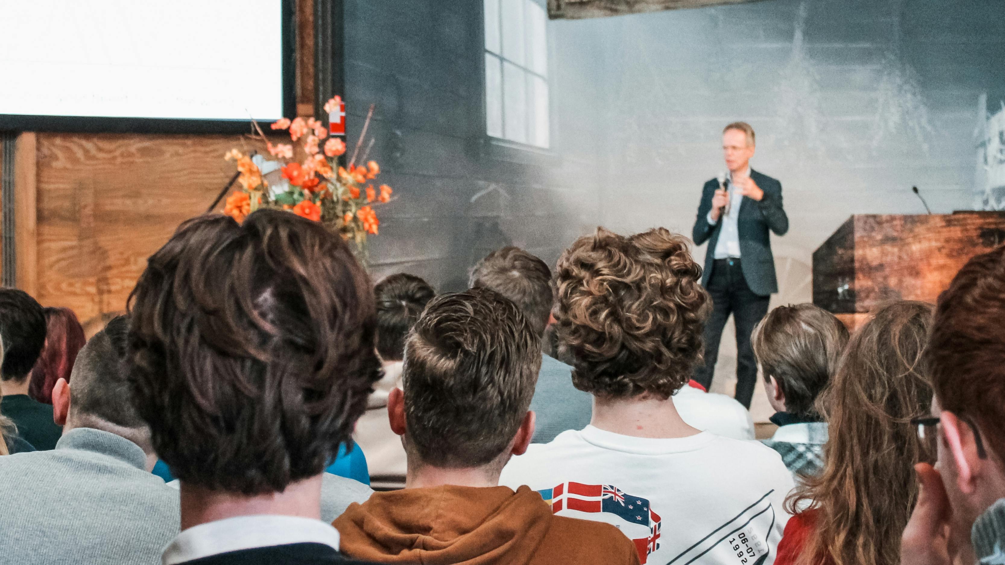 Man in pak die presenteert voor een publiek