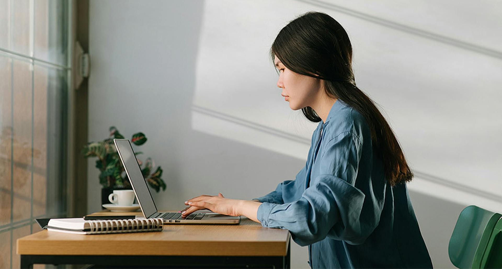 An image of a woman sitting with her laptop.