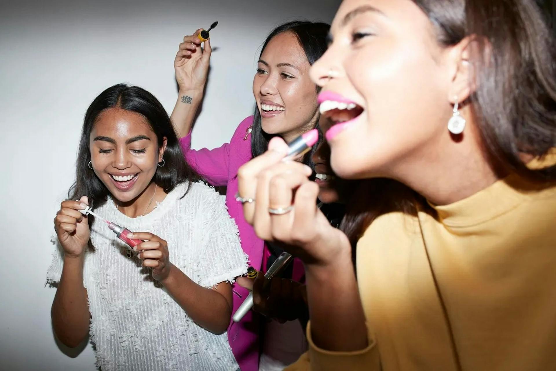 Gen Z women applying lipstick.