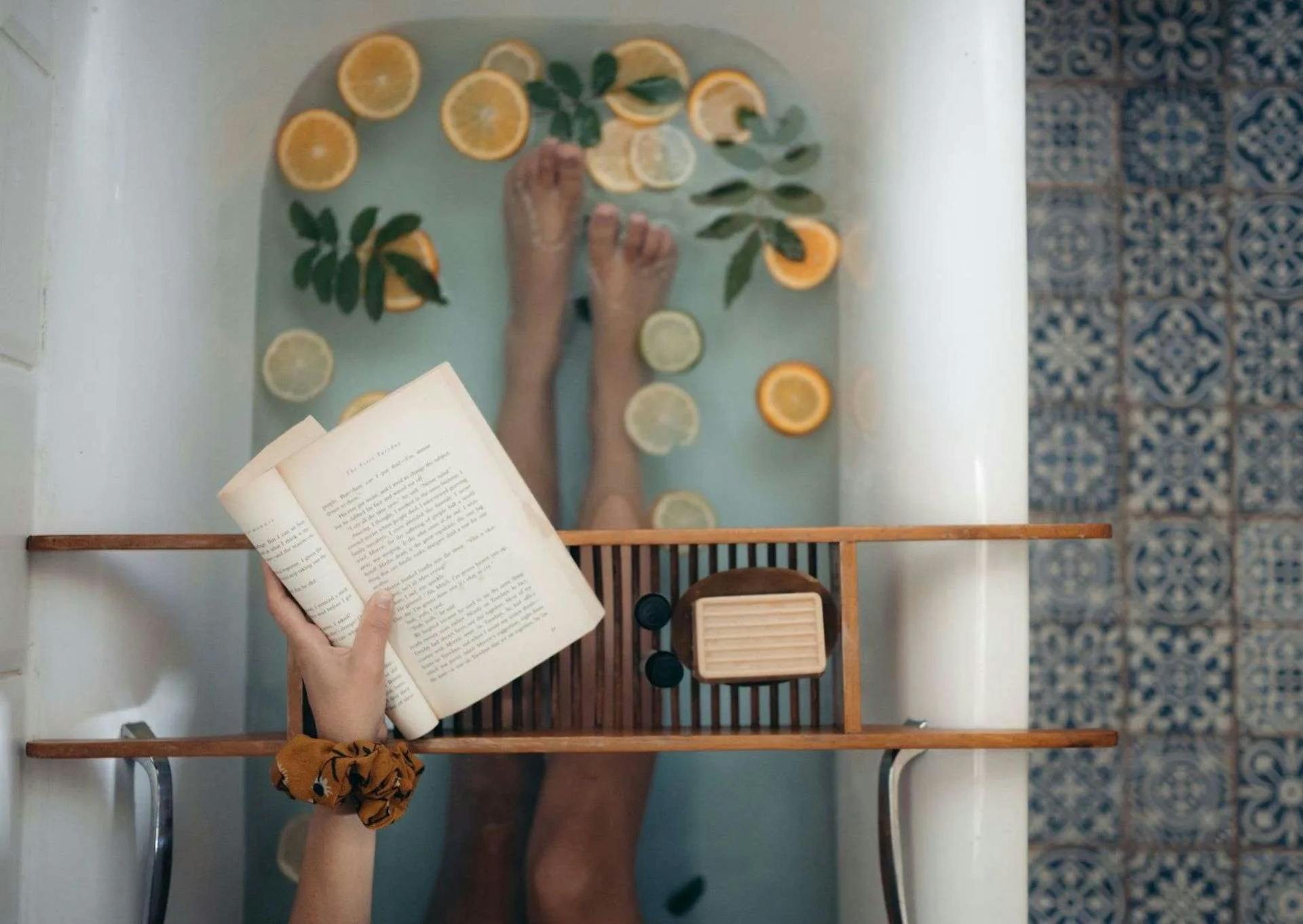 Woman reading book in a bath tub.