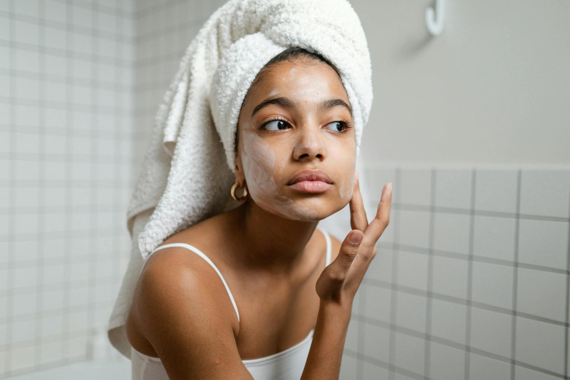A woman applying a face mask.