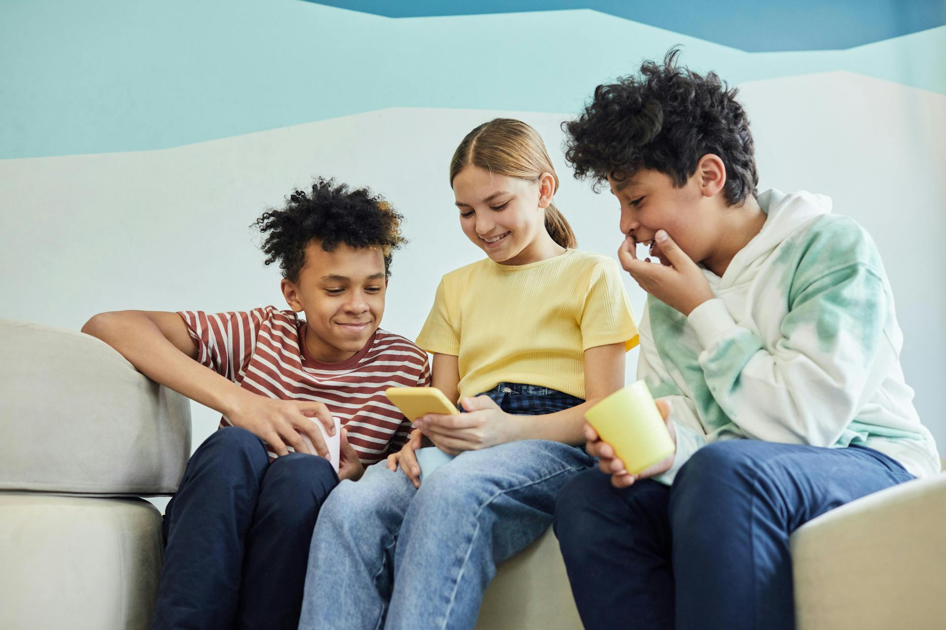 A group of children looking at a smartphone.