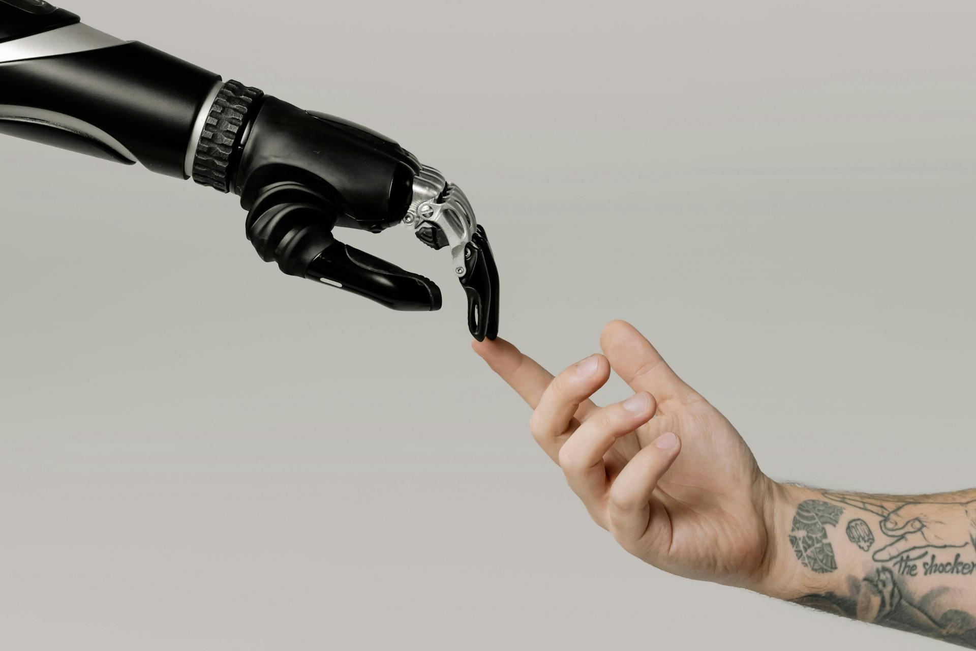 A robot and a human hand touching fingers.