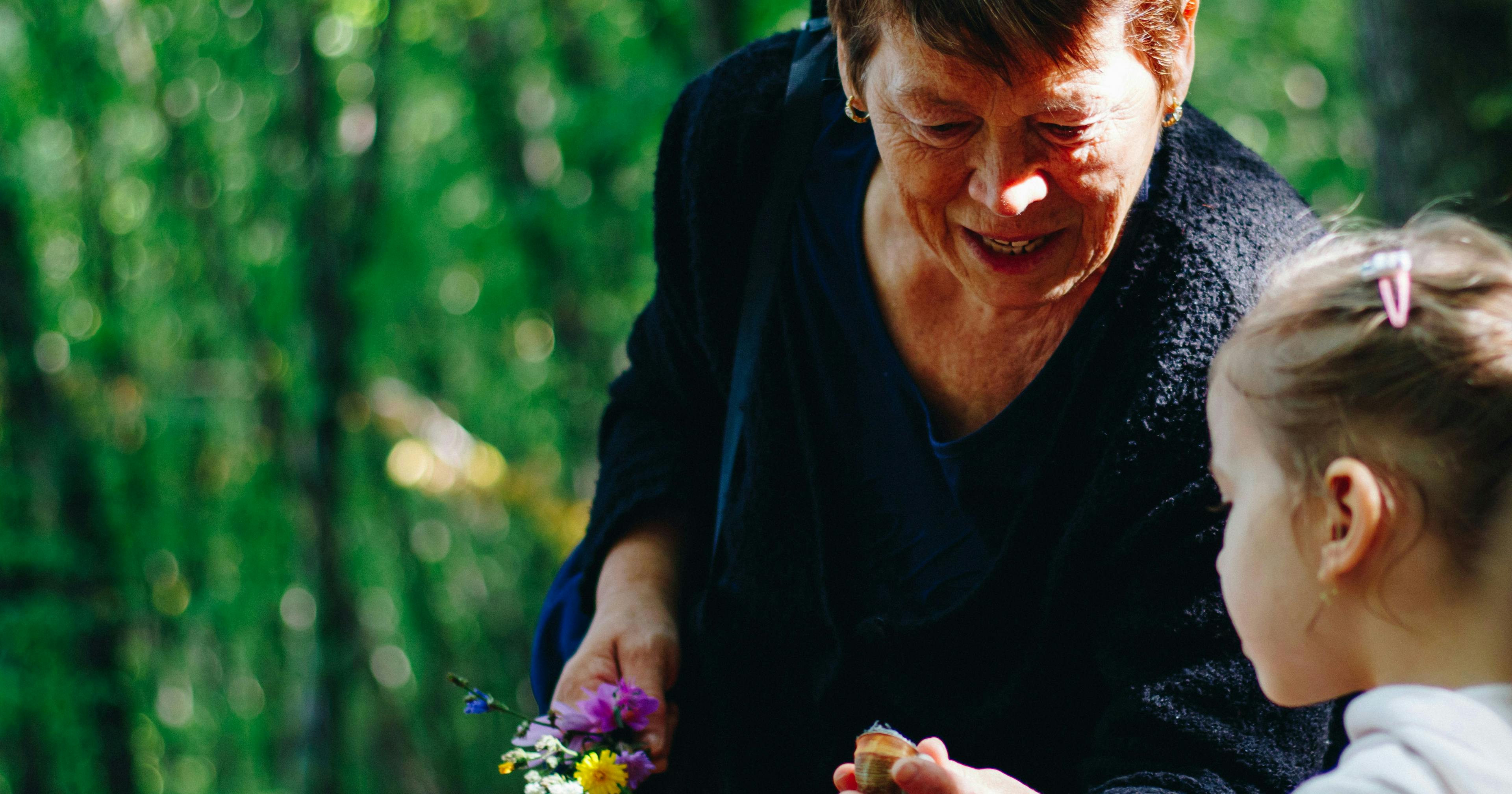 a grandparent shows an acorn to their grandchild