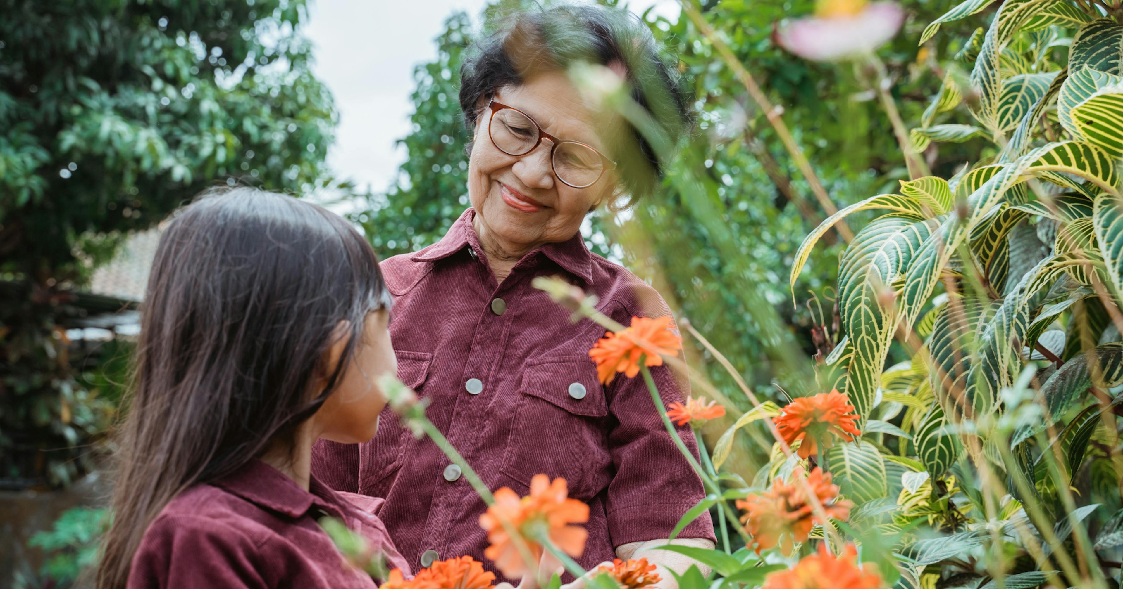 a grandmother walks in a garden with her grandchild
