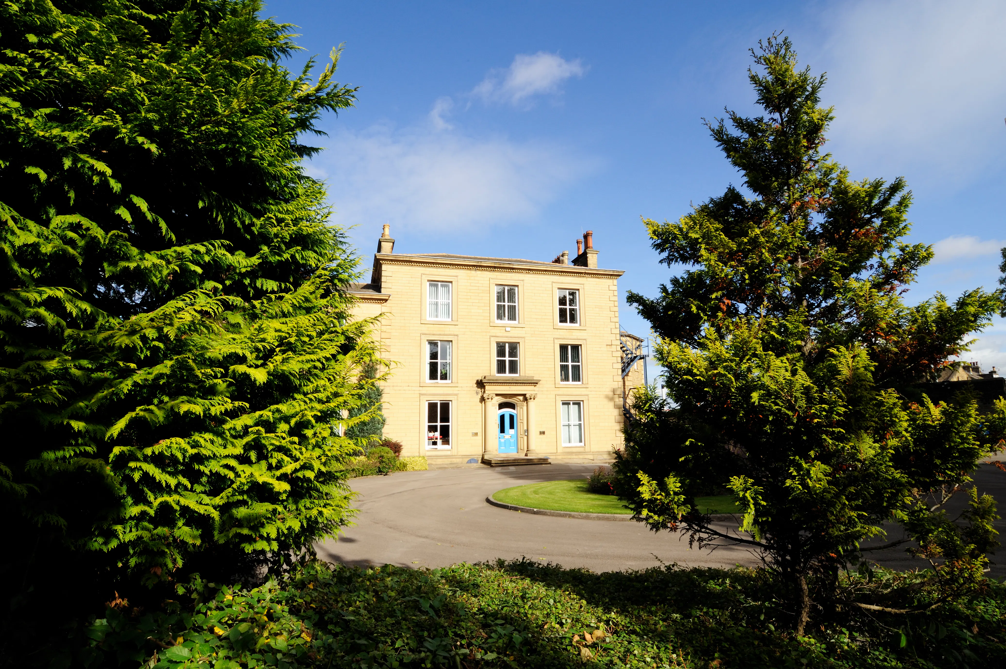 mature trees with leigh house in the distance