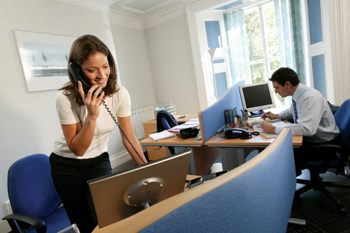 3 person office occupied with people on telephone and computer