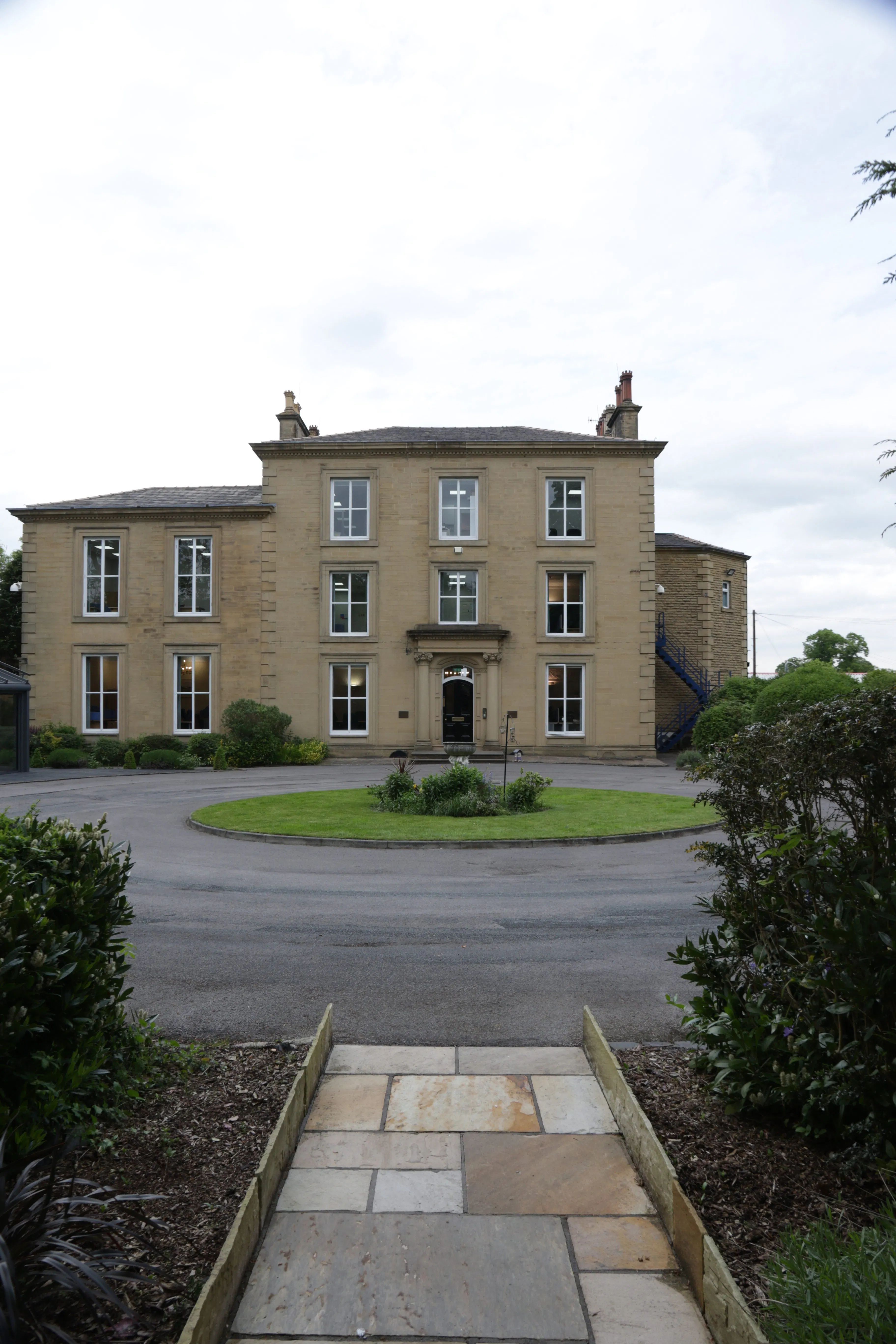 large historic building in leeds with path and circular driveway