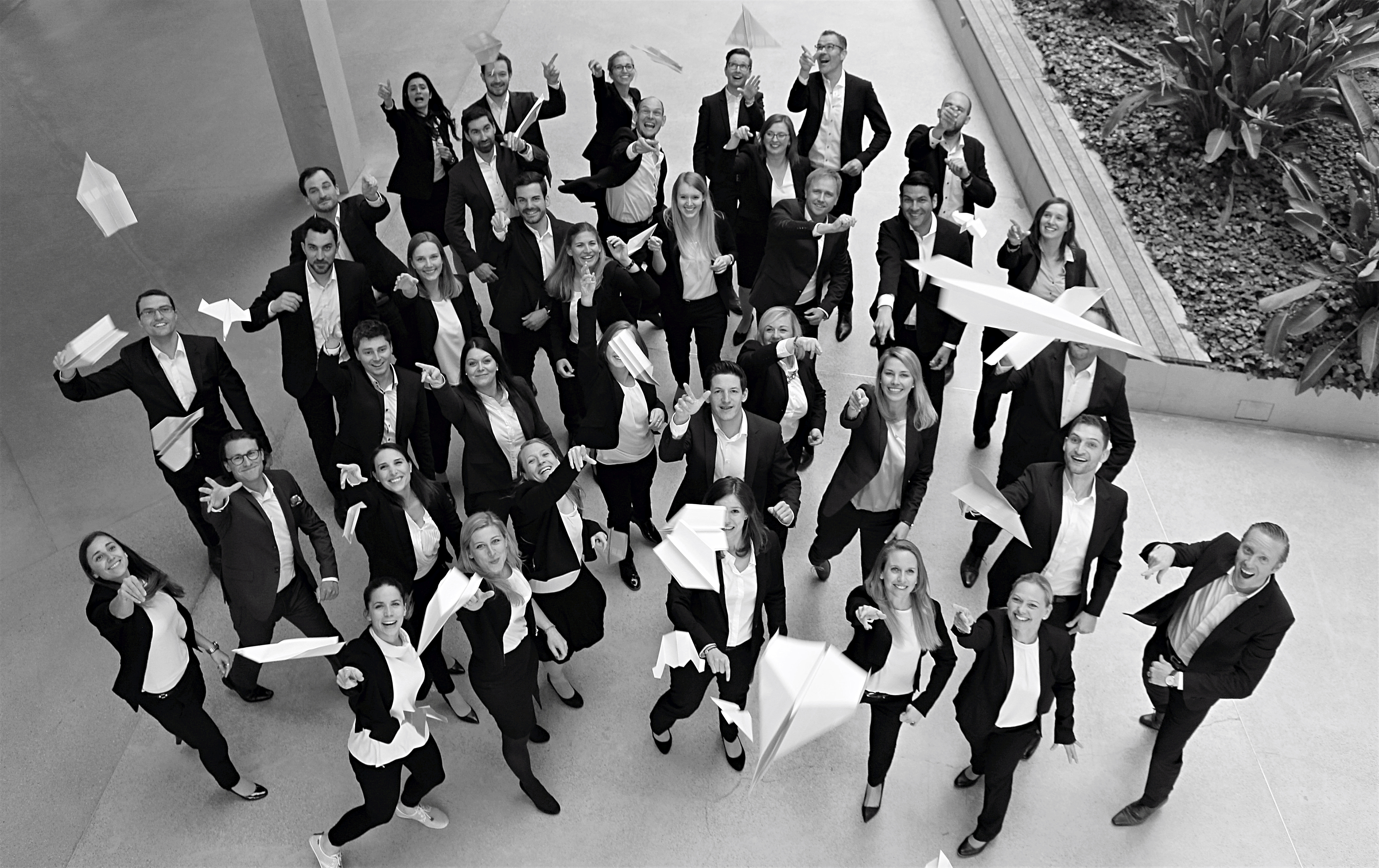The Leitwerk Consulting Team throwing paper planes in the air
