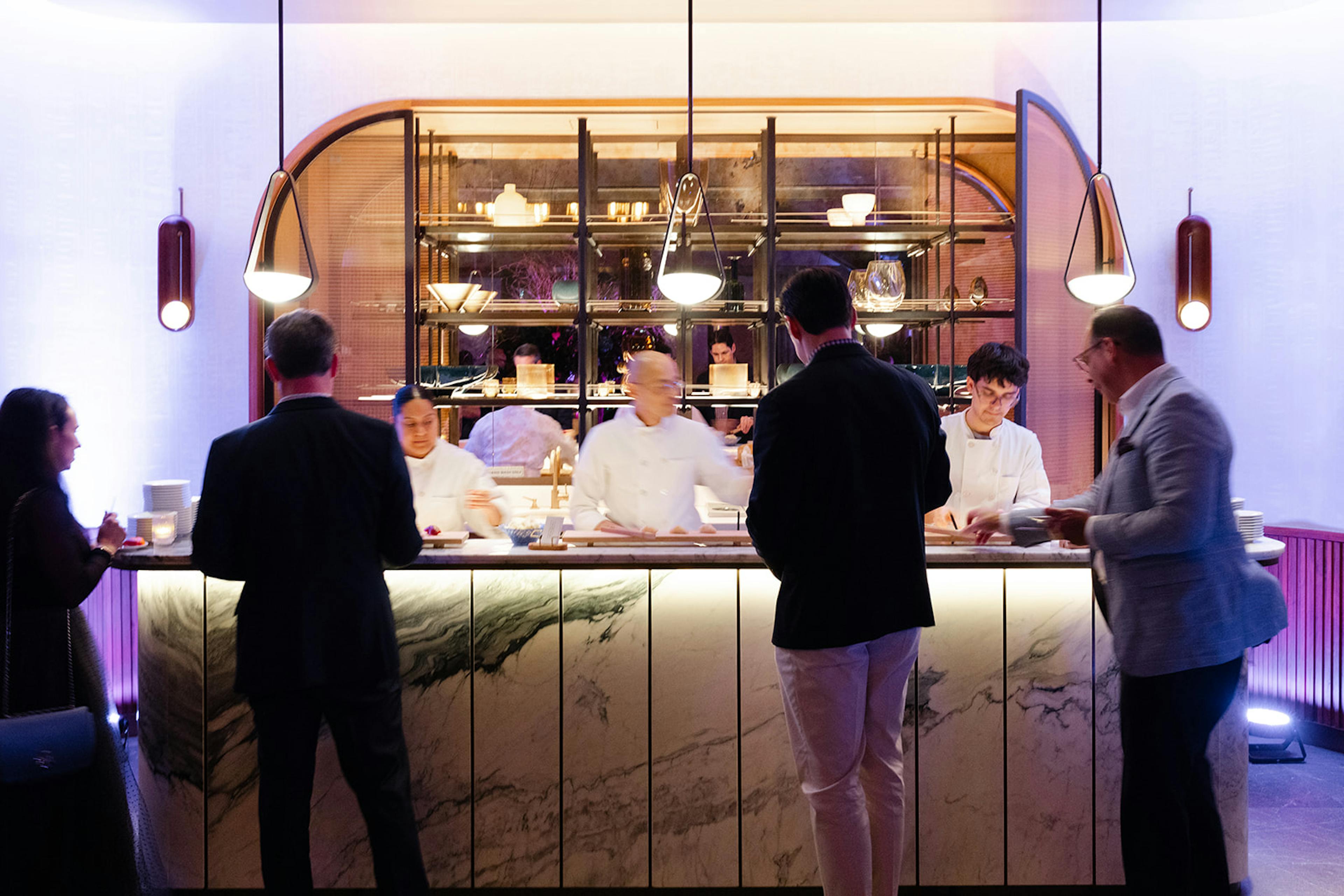 sushi bar with chefs serving guests