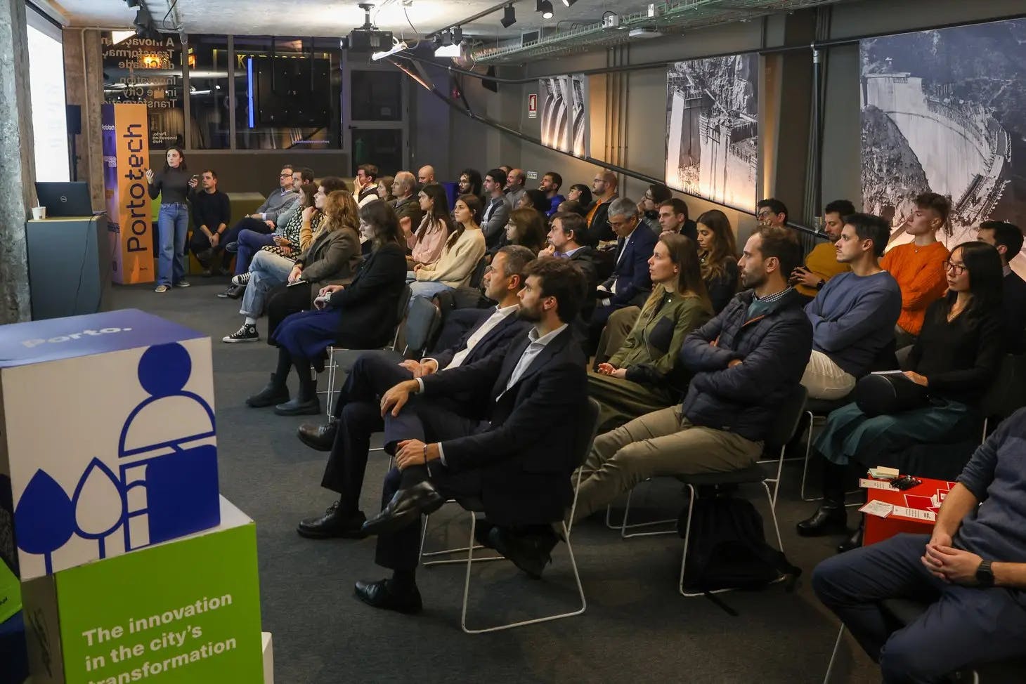 Grupo de pessoas sentadas numa plateia a assistir a uma apresentação