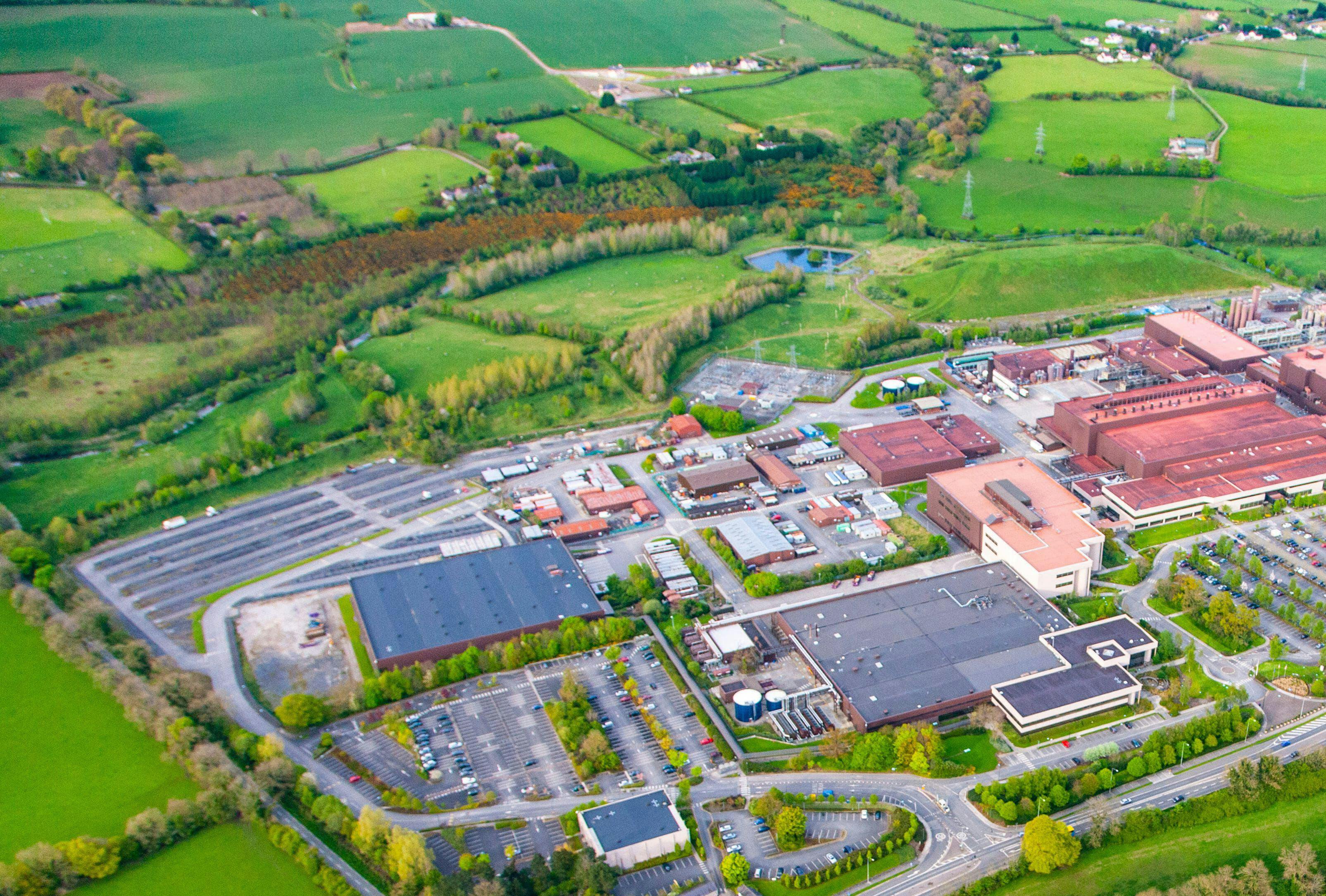 An arial view of a generic manufacturing facility, surrounded by countryside and housing developments