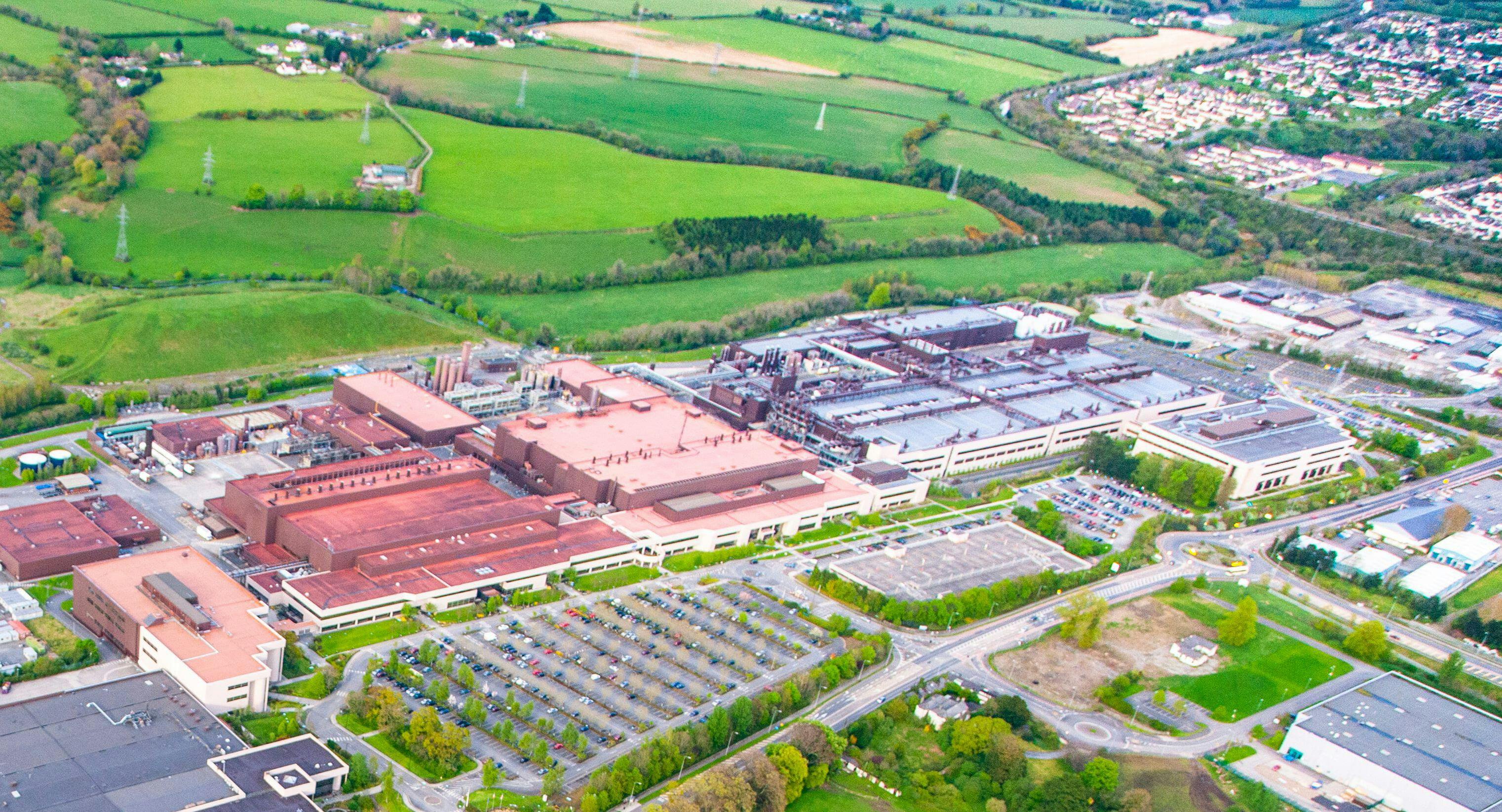 An arial view of a generic manufacturing facility, surrounded by countryside and housing developments