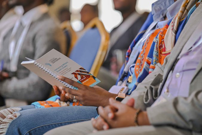 A participant at #ALG2024 reviewing the event program and booklet.