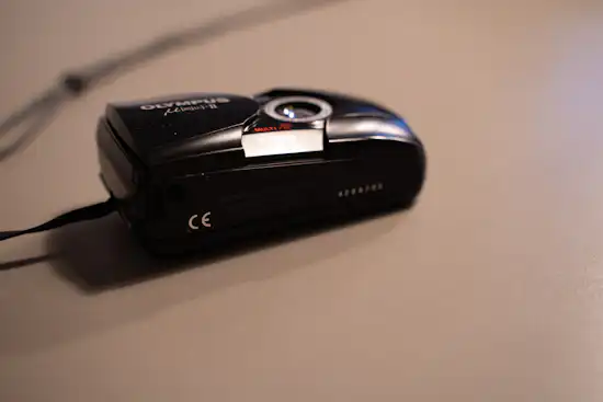 A photograph of the bottom of the Olympus Mju II camera.