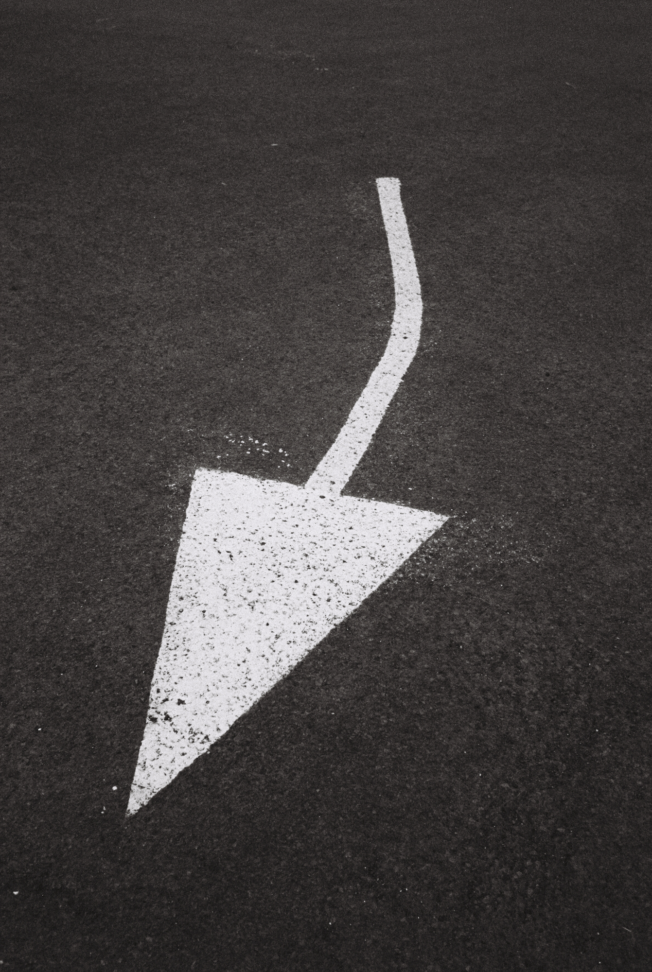 White arrow painted on a road.