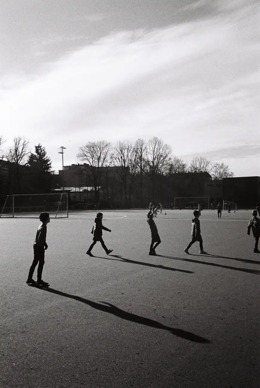 Kids playing football. Long shadows.