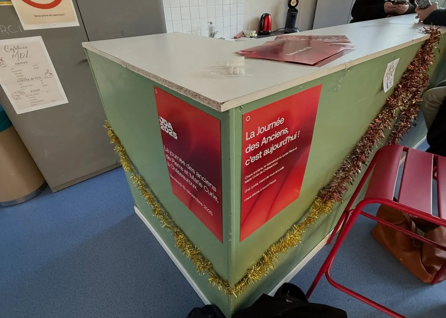 Le comptoir d’accueil décoré de guirlandes, avec les affiches « La Journée des Anciens, c’est aujourd’hui ! »