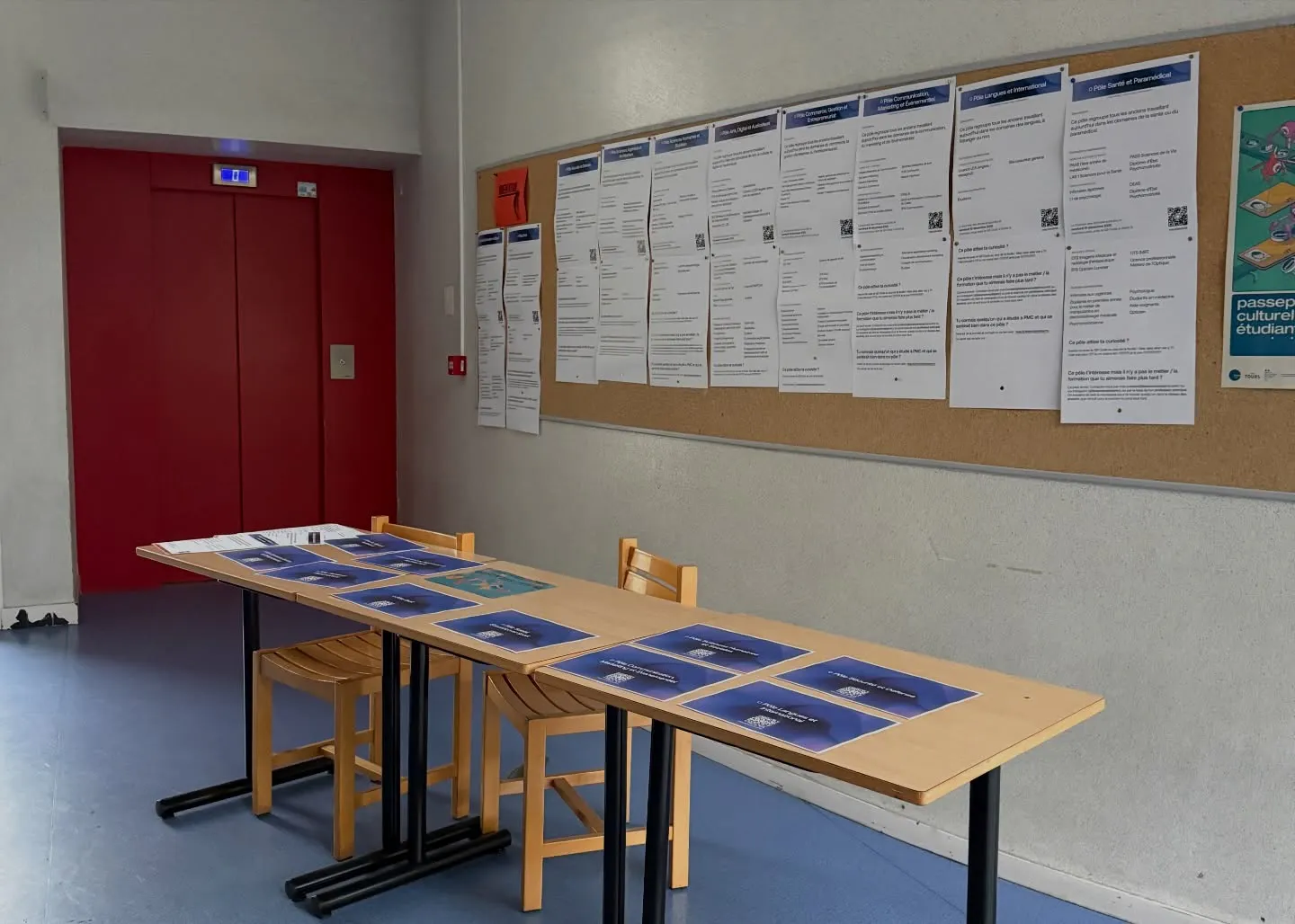 Une salle préparée pour les élèves, avec les affiches des pôles métiers sur les tables et le programme au mur