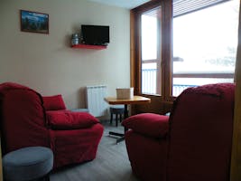 Un salon avec TV et canapé couchage en 140