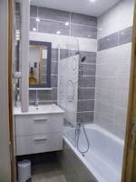 Salle de bains avec baignoire et meuble lavabo