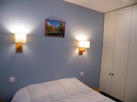 Chambre parentale avec fenêtre donnant sur le salon et placards