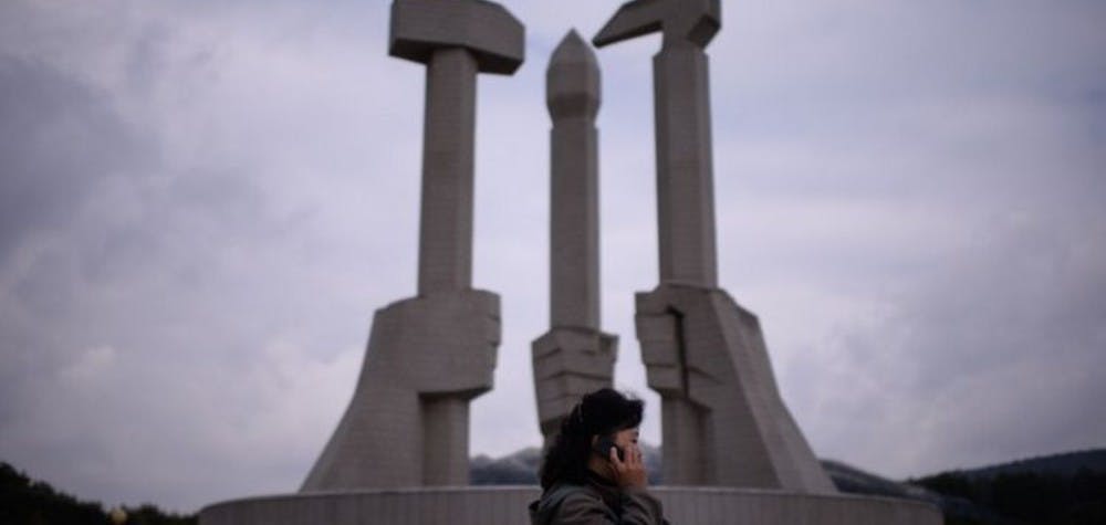 Femme nord coréenne avec son téléphone portable.