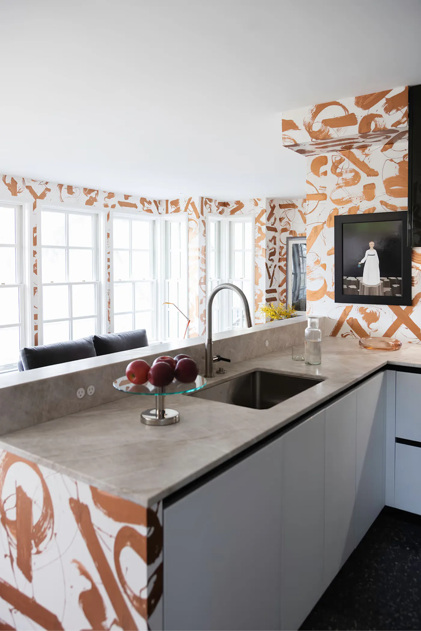 Modern kitchen design with hand-painted mural walls, stone countertops, integrated sink, and open view to living space