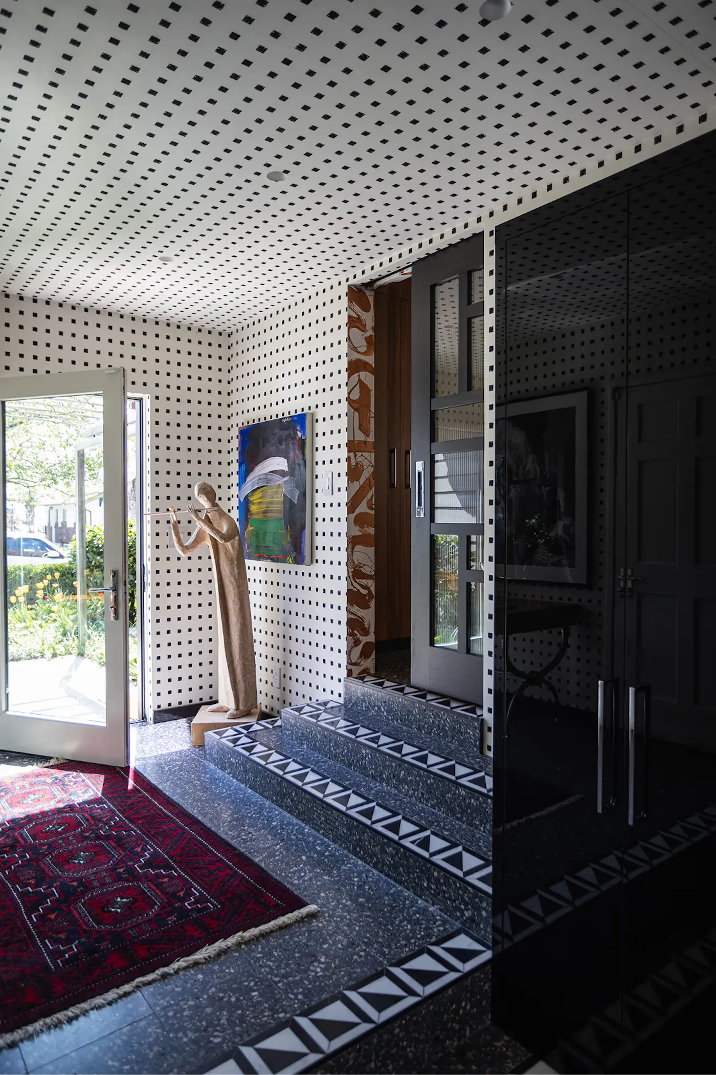 Salt Lake City interior design entryway with patterned walls, terrazzo flooring, and sculptural decor